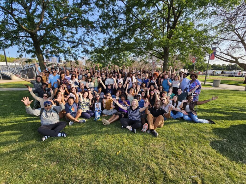 Employee Productivity - people on lawn taking an enthusiastic group photo