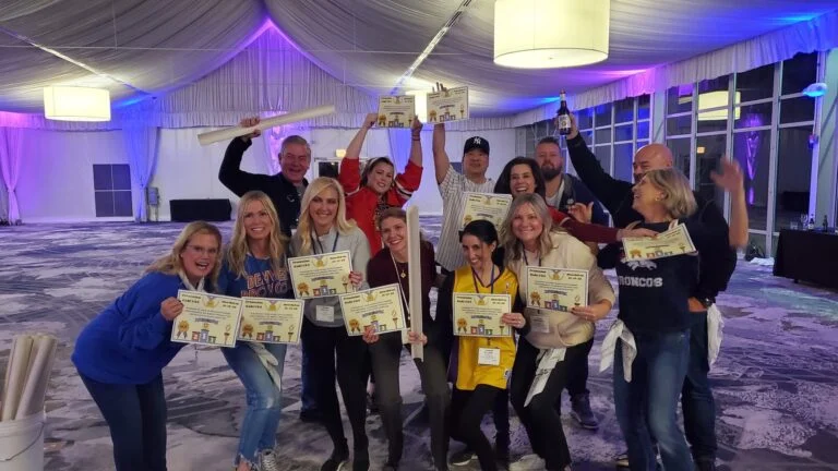 Office Olympics - Group celebrating with certificates indoors.