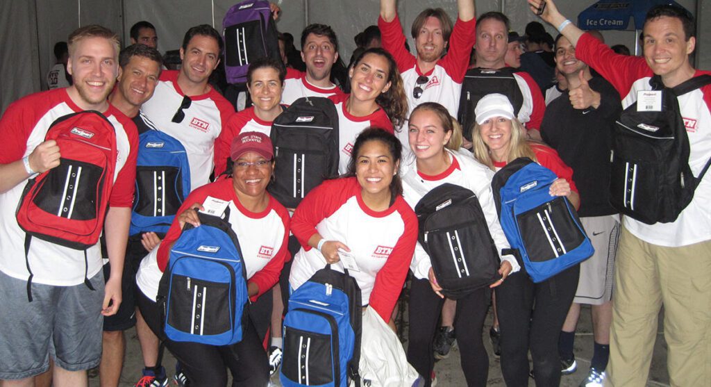 Team showing off the backpacks for a cause that they packed for charity